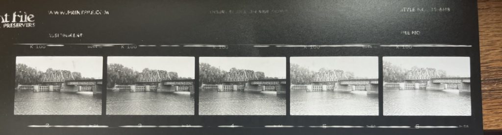 A photo of a proof sheet that shows 5 shots of a bridge. The shots go roughly from darkest to lightest from left to right.