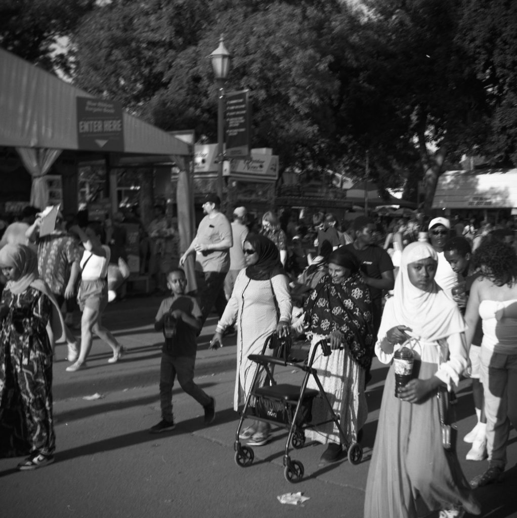 A black and white photo of a multiple generations of a family enjoying the state fair.