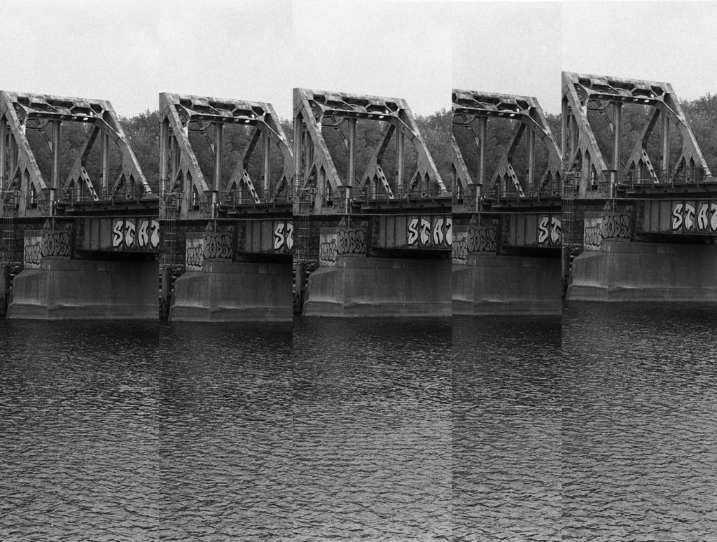 Five nearly-identical black and white photos of a steel bridge truss that crosses the Mississippi River. The light levels and shadows in each are very similar.