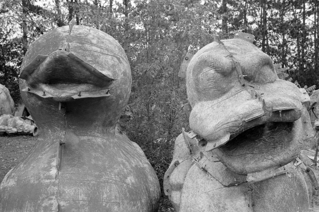 A black and white photo of two fiberglass molds of rubber ducks. One of the ducks seems quite happy, while the other one looks sarcastic and angry.