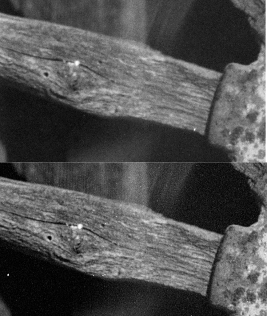 A close-up comparison of two scans of a black-and-white photo of a wooden wagon wheel spoke. In the top scan of the old scan the details and grain are blurry and the contrast lower. In the bottom scan the grain is sharper and the contrast is higher.